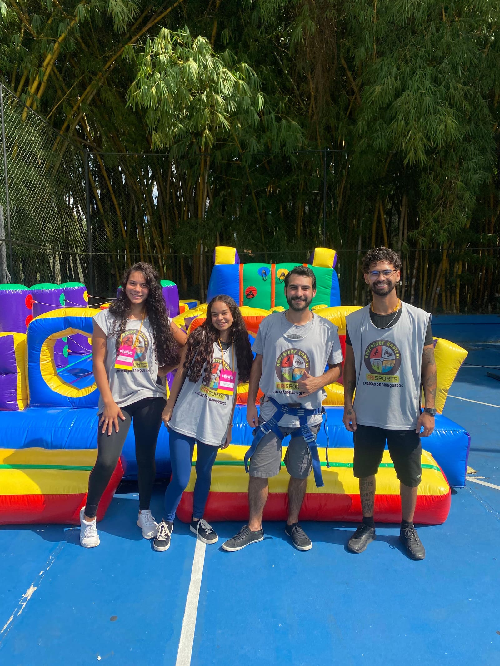 Equipe Frisports uniformizada em frente a estrutura inflável de obstáculos